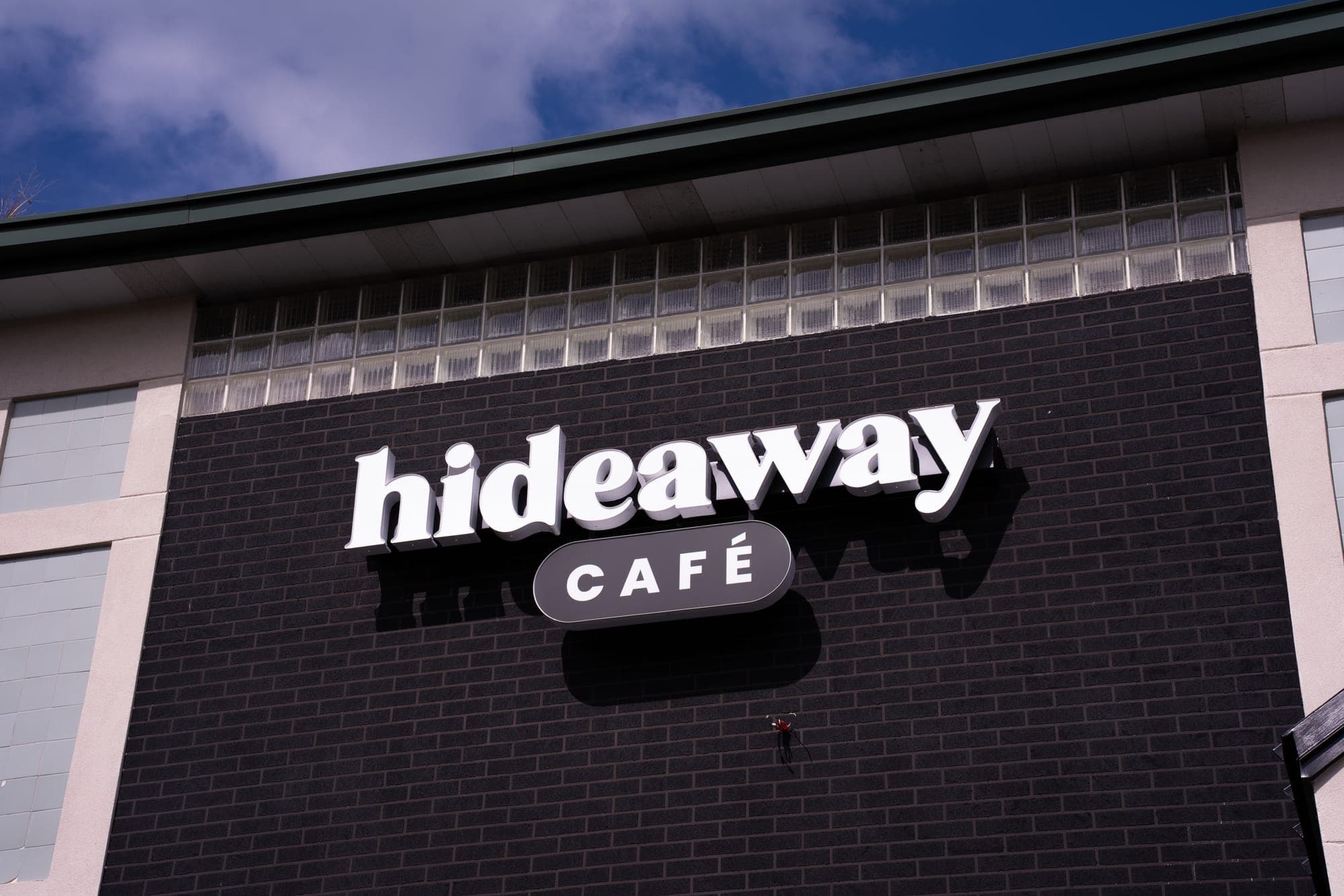 The hideaway café sign on the dark brick storefront